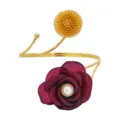 Detailaufnahme der goldenen verstellbaren Armmanschette mit Blumenkugel und Perlenstoffblume. - Kamelie Rot