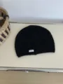 Detail shot of a black knitted hollow-out beanie hat with a small REMAKE label for casual wear. - 26*20cm / Black