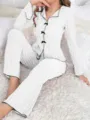 Detail view of white rib-knit pajama set with black bows and ruffled sleeves - White