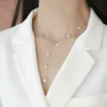 Elegante collana a Y con perle d'acqua dolce su una modella con un blazer bianco - Naturale / Argento Con Perla d'Acqua Dolce Bianca