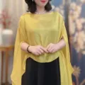 Detail view of women sheer pullover cape shawl in bright yellow, lightweight summer outerwear. - Turmeric