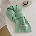 Primo piano dettagliato di una morbida sciarpa invernale in maglia verde menta, comoda a coste. - verde mela