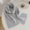 Dettaglio della sciarpa in maglia grigia, accogliente trama a costole per l'inverno, morbido accessorio. - Grigio