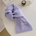 Primo piano dettagliato di una morbida sciarpa lavorata a maglia viola con trama. - Viola