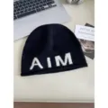 Black knitted beanie hat with white AIM letters, soft warm winter wool skull cap for women. - One Size / Black