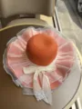 Großkrempiger Strohhut Detail, orangefarbene Sonnenhut mit weißer Schleife und Netz, Sommer - Orangerot