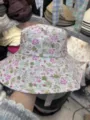Detail view of a floral print bucket hat with a wide brim, casual style for women and girls. - Small Flower Purple-Green
