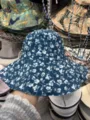 Detailansicht des blauen Blumen-Fischerhuts mit zartem weißem Blumenmuster und breiter Krempe. - Blume Blau