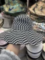 Detailansicht eines stylischen schwarz-weißen Pünktchen-Hutes mit breiter Krempe für Sommertage. - Kleine Punkte Schwarz