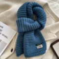 Blue knitted wool-blend scarf detail, cozy winter warmth texture, soft fashion accessory. - Blue