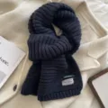 Detailed shot of a cozy dark blue knit winter scarf, thick warm woolen texture for women. - Navy Blue
