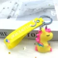 Schattige eenhoorn sleutelhanger met regenboogband, leuke tasbedel voor dames en meisjes. - Gele zittende eenhoorn