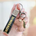 Schattige geometrische dinosaurus sleutelhanger met lederen polsband stijlvolle tas charm accessoire - koffiekleur
