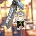 Modieuze astronaut vloeibare drijfzand sleutelhanger met gouden sterrenglitter. - Individuele Verpakking / Zwart-gouden astronaut - staand geel gezicht