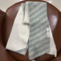 Gros plan sur l'écharpe en maille rayée confortable, texture douce et étiquette. - Beige à rayures vertes et grises