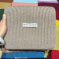 Dettaglio di sciarpa in maglia morbida, costine calde, primo piano accogliente invernale. - Sciarpa grigio beige con motivo a lingotto