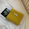 Vista dettagliata della sciarpa in maglia giallo senape con etichetta, calda sciarpa invernale. - Giallo