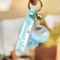 Blauwe vloeibare drijfzand lolly sleutelhanger met siliconen band en glinsterende glitterdetails. - Blauw