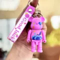 Schattige roze beren sleutelhanger met riem, stijlvolle tassenhanger en auto-accessoire. - Lichtpaars