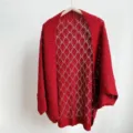 Red hollow knit cardigan detail shot, showcasing the delicate diamond pattern and loose sleeves. - Red