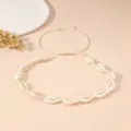 Collana di conchiglie naturali con cordino beige regolabile su sfondo minimalista - Collana