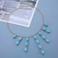 Detailliertes Flatlay einer Vintage-Halskette mit ovalem Türkis auf blauem Grund - Cyan