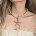 Close-up of golden textured starfish pendant necklace on model neck for elegant summer jewelry. - Single Necklace / Off-White Rope