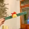 Gros plan du détail du bracelet slap en peluche de Noël avec cloche jaune et nœud rouge. - Bracelet slap Cloche
