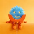 Cute orange sponge holder with draining legs and blue smiley sponge for kitchen sink organization. - Orange