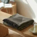Close-up of vintage cotton jacquard throw blanket texture with elegant fringe and pattern - Inky Hazel