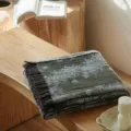 Detailed view of vintage jacquard throw blanket with fringe, cozy cotton texture style. - Qingye Green