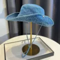 Close-up detail of the vintage washed denim bucket hat with windproof rope and metal buckle. - Blue