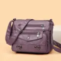 Borsa a tracolla viola in pelle morbida con tasche multiple e cuori in metallo. - Viola