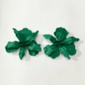 Detailopname van groene metalen bloemoorringen met een ingewikkeld gelaagd bloembladontwerp. - Groen