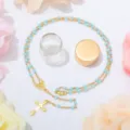 Collana rosario perle blu con ciondolo croce e bottiglia di vetro, elegante gioiello religioso. - Blu