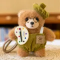 Cute brown bear plush keychain with green overalls and artist palette accessory item. - Artist - Striped Pants