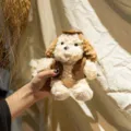 Cute mini egg tart dog plush toy detail view, holding plush puppy doll with brown vest and hat. - Cowboy Style