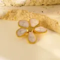 Detailopname van de elegante vijfbladige bloembroche met gouden rand en roze emaille. - Broche / Wit