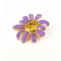 Primo piano dettagliato della spilla floreale in smalto viola, in acciaio inox dorato. - Spilla / Viola