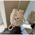 Detailed view of hollow macrame bucket bag, cotton rope weave, casual beach resort style. - Drawstring / White