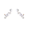 Detailopname van asymmetrische oorbellen met glanzende witte parels en schitterende steentjes. - Gouden Multi Parel Cluster Stijl (M230228043)