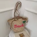 Sac de plage en paille tressée avec poignées en cuir et broderie rose pour l'été. - Rose rouge