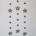 Black paper garland detail featuring hollow stars, circles, and number 50 for party decor. - Black 50th Birthday Banner