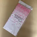 Detailopname van roze stippen wegwerp tafelkleed verpakt in doorzichtige plastic zak. - Wit tafelkleed met roze stippen 137*274 cm