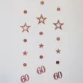 Rose gold 60th birthday hanging garland with metallic stars and number 60 cutouts for party. - Rose Gold 60th Birthday Garland