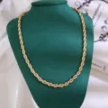 Detailweergave van een klassieke goudkleurige getwiste touwketting halsketting op display. - Kettingstijl