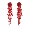 Detailed close-up of red beaded rose tassel earrings, featuring intricate floral drop design. - Red