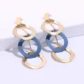 Detailopname van geometrische meerlagige hangende oorbellen in goud en blauw metaal. - Lichtblauw + Goud