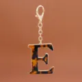 Detailansicht Buchstabe E Schlüsselanhänger Acetat Leo-Muster, goldene Metalllegierung. - Buchstabe E