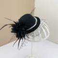 Close-up of black vintage miniature pillbox hat with elegant veil, pearls, and feather flower. - Fascinator Hat with Hair Clip / Black